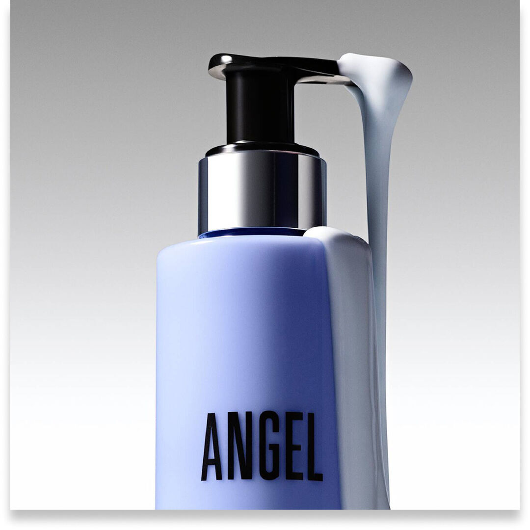 Close-up of a Mugler Angel body lotion pump bottle with white lotion on the dispenser.