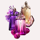 Three Mugler Alien fragrance bottles – classic purple Alien Eau de Parfum, new pink Alien Pulp, and golden Alien Goddess – surrounded by vibrant berries and flowers, highlighting the scent variations.