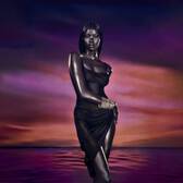  Stylized image of a woman in a dark, draped garment, standing gracefully against a dramatic purple and orange sunset over water