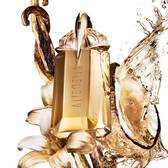 Alien Goddess perfume bottle surrounded by vanilla, flowers, and splashing golden liquid