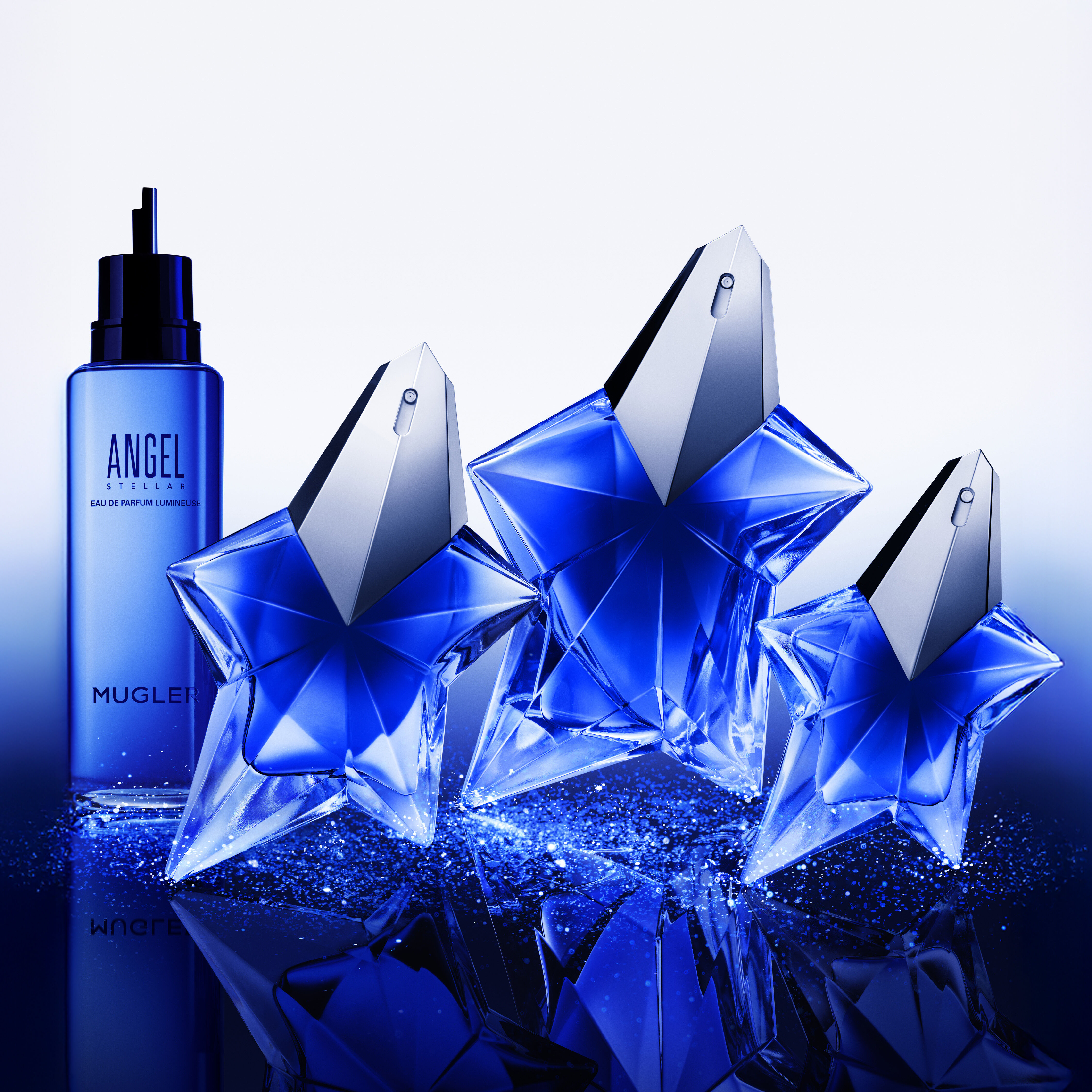 Angel Stellar Eau De Parfum in sizes 25ml, 50ml, 100ml and 100ml refill bottle lined up against a white and blue sparkly background.