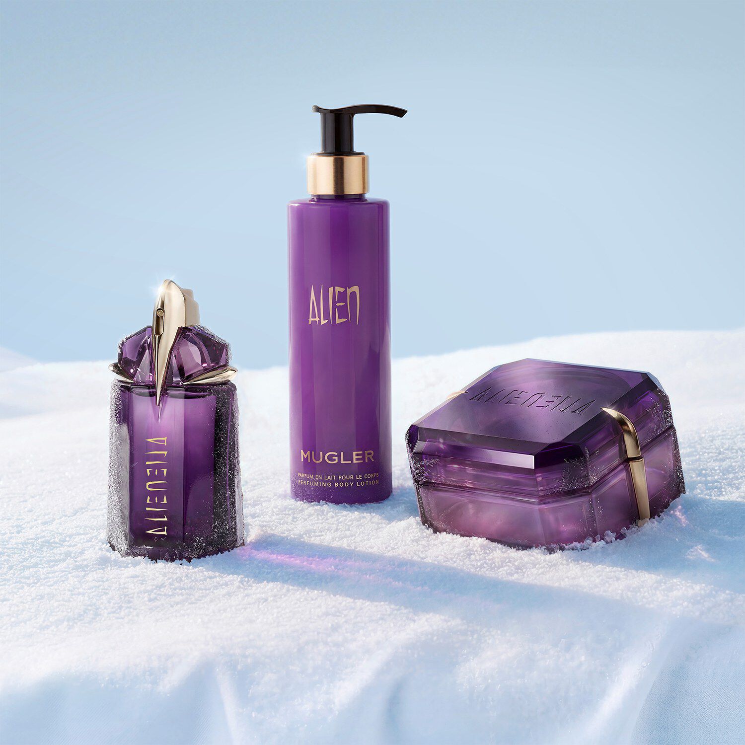 Mugler Alien body care and perfume set on a winter snow background.