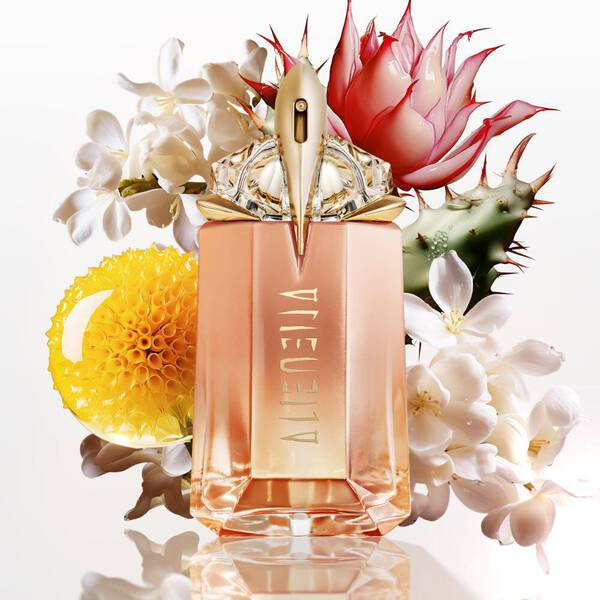 Alien perfume bottle with white flowers, cactus, and yellow blossom.