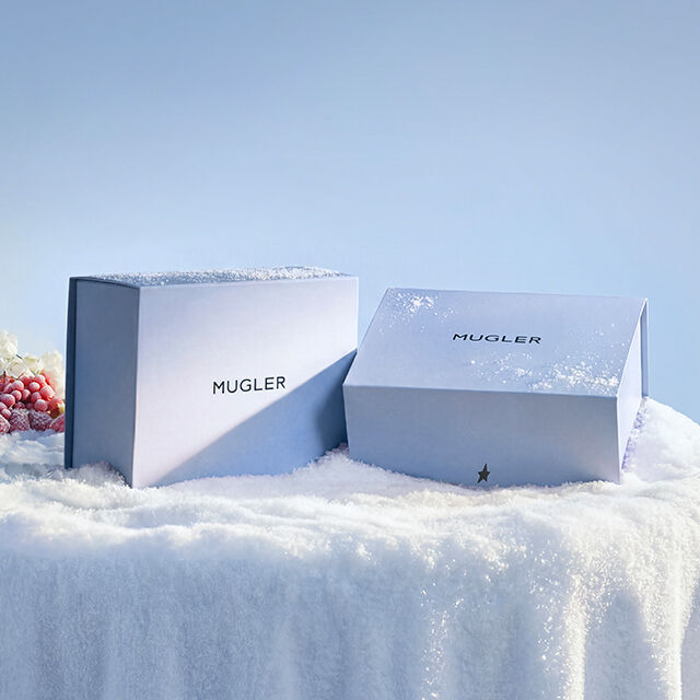 Mugler luxury holiday gift box packaging on a snowy surface.