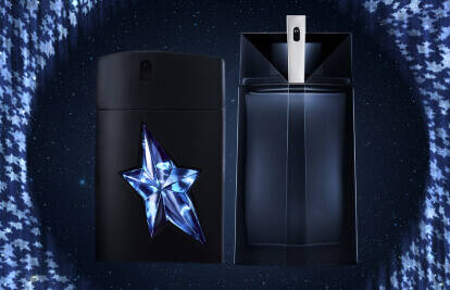 A visually striking display featuring two perfume bottles against a backdrop of starry skies. The left bottle is black with a prominent three-dimensional star design, while the right bottle is sleek and angular.