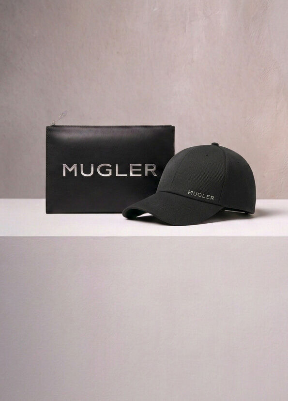 A Mugler branded black pouch and a black baseball cap displayed on a neutral surface, representing the rewards boutique gifts.
