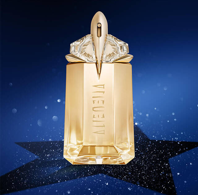 A golden perfume bottle with a geometric design and an elegant cap, set against a starry blue background.