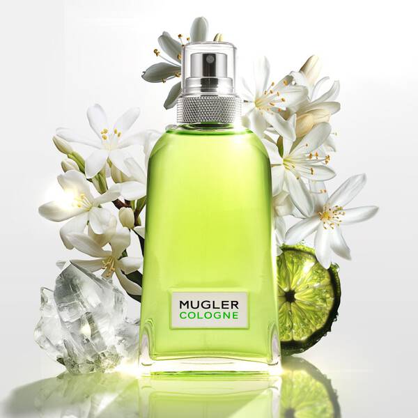 Mugler Cologne perfume bottle, white flowers, lime slice, and crystals.