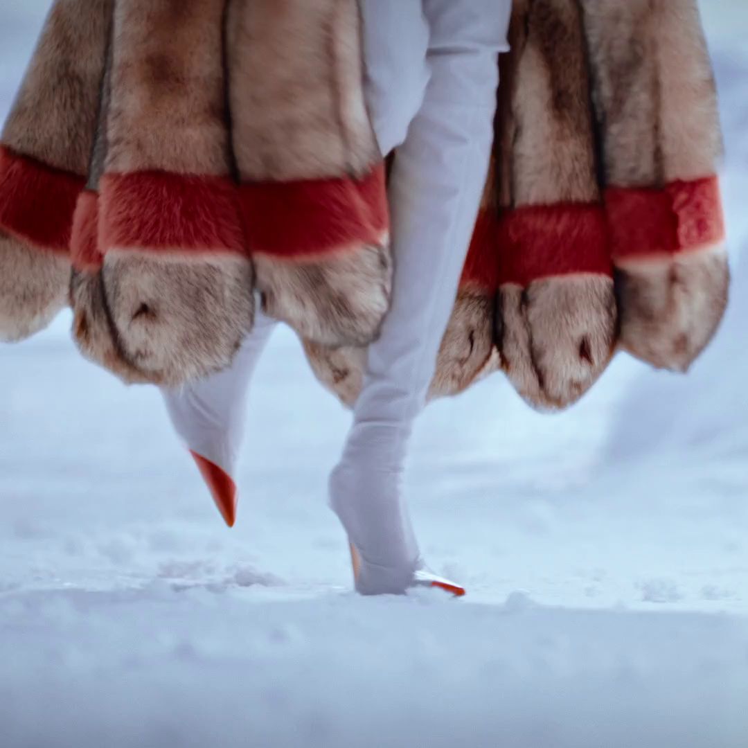 mugler the frozen hour hero film. A Mugler holiday campaign video set on a snowy glacier. Models in luxury faux fur coats gather around a banquet table decorated with red roses. The iconic purple Alien EDP and pink star-shaped Angel Nova perfume bottles are showcased nestled in the snow alongside fresh raspberries.