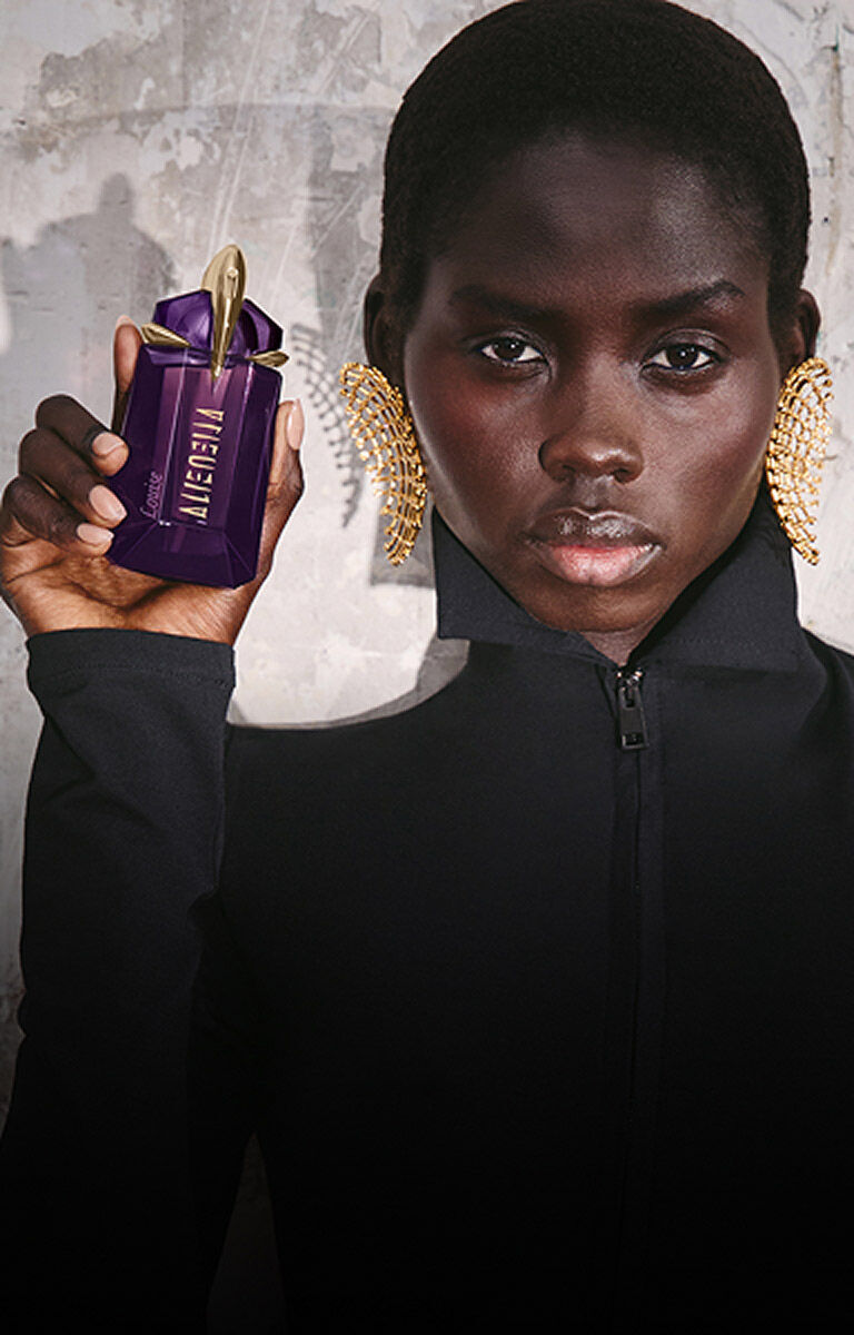 Model holding a purple Mugler Alien Eau de Parfum bottle next to a review prompt.