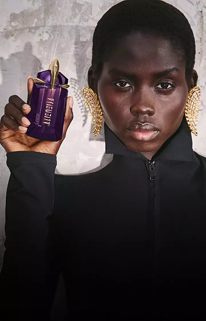 Model holding a purple Mugler Alien Eau de Parfum bottle next to a review prompt.