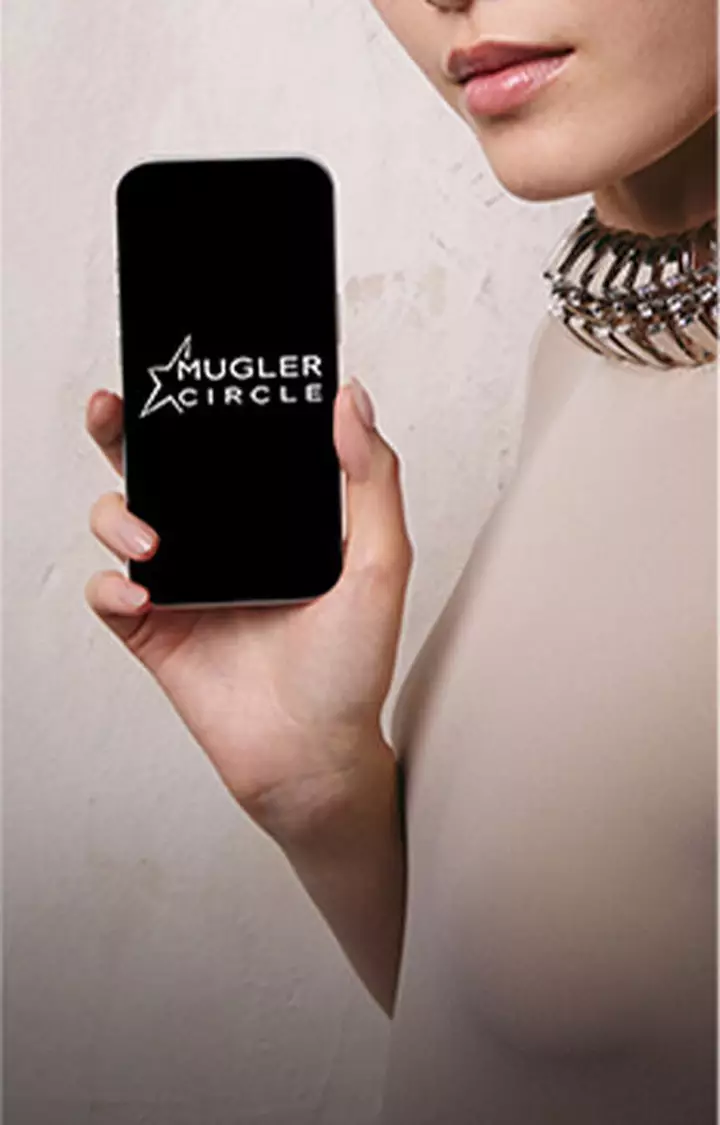 Hand holding a smartphone displaying the Mugler Circle logo.