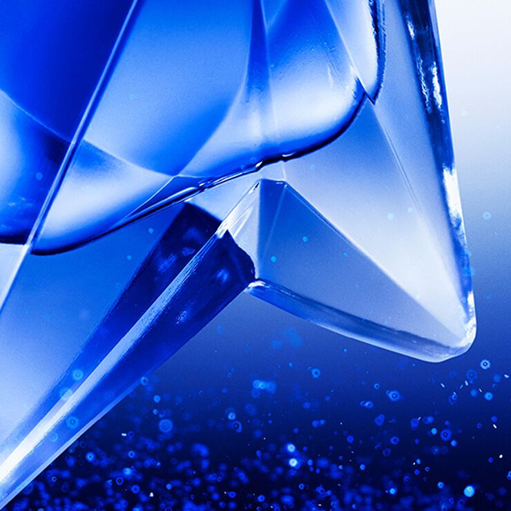 close-up of the Angel Stellar eau de parfum bottle on glitter, highlighting its facets.