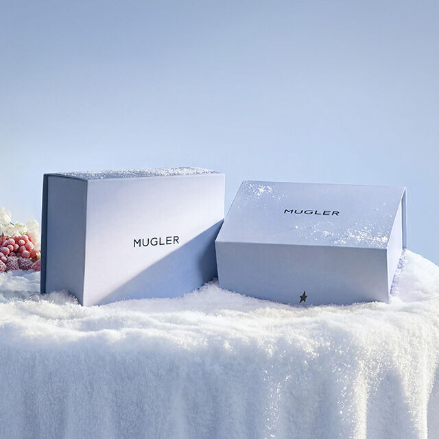 Mugler luxury holiday gift box packaging on a snowy surface.