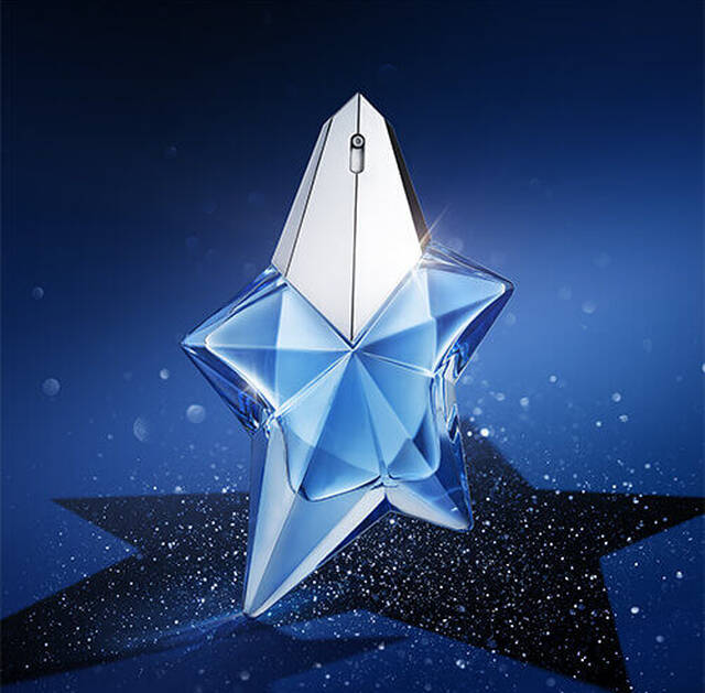 A blue star-shaped perfume bottle with a reflective silver cap, set against a deep blue background with sparkling elements.