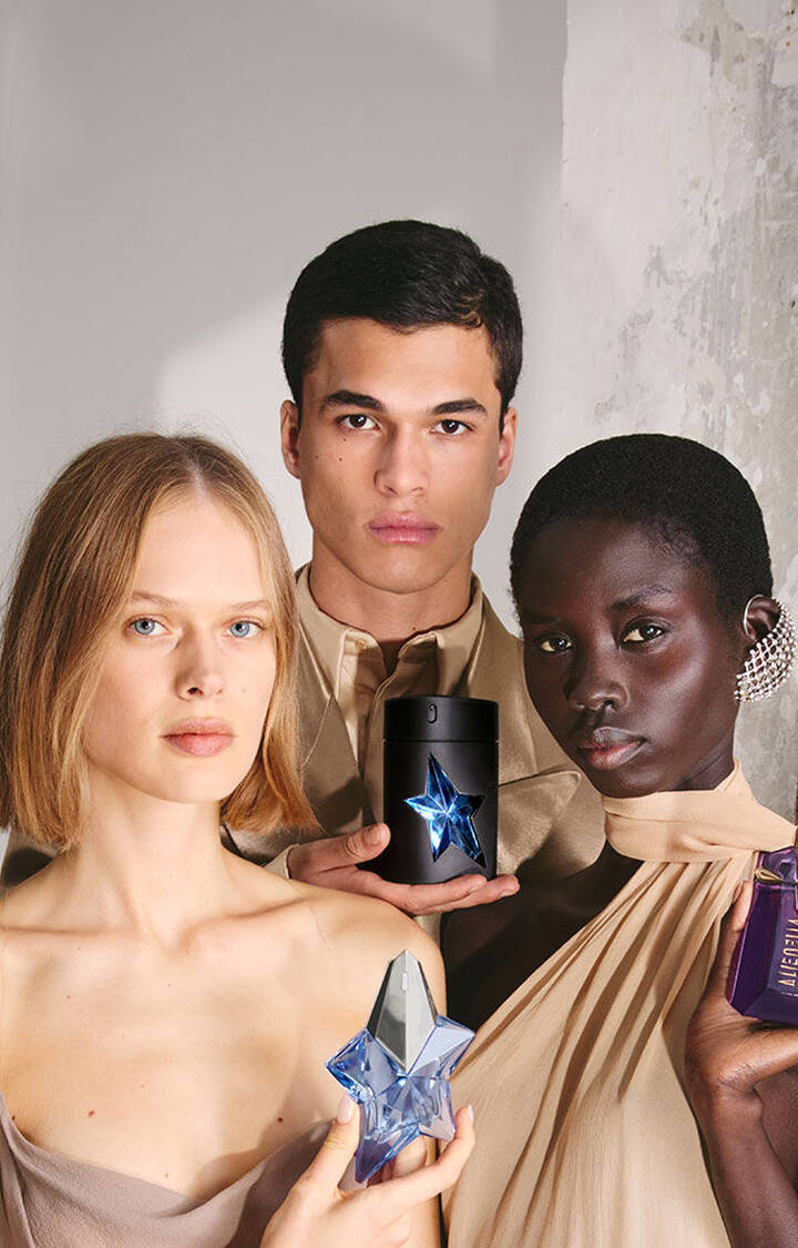 Diverse group of models posing with Mugler fragrances including Angel, Alien, and A*Men.