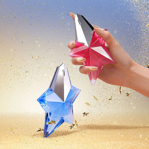 An image showing two star-shaped perfume bottles, one pink held by a hand emitting glitter, and one blue on a sparkling sand and sky background, both surrounded by golden stars.