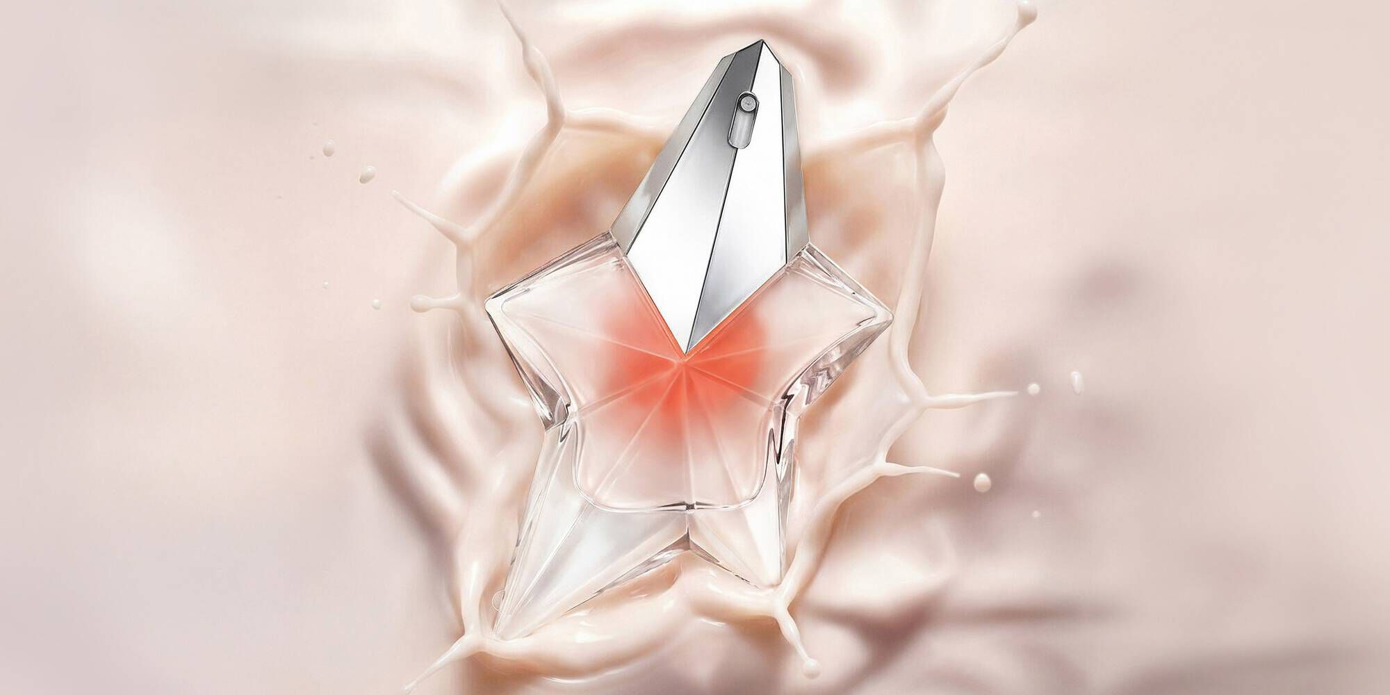 A star-shaped glass perfume bottle with a silver cap splashing into a smooth, creamy pink liquid.