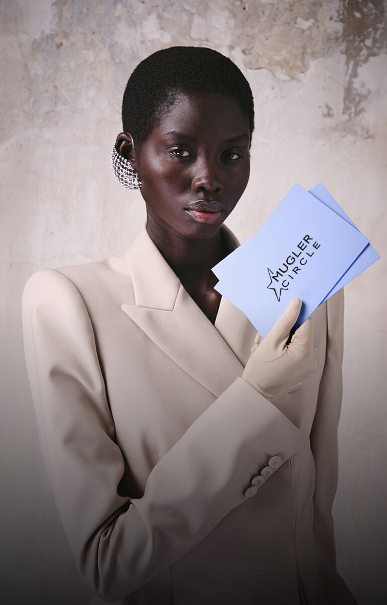 Model holding a Mugler birthday gift envelope and card.