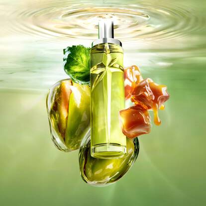 A green star-shaped perfume bottle floating in water with pistachios and caramel.