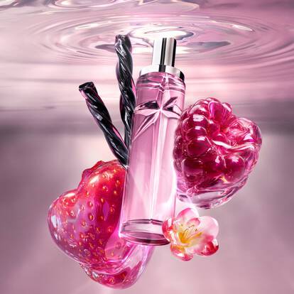 A pink star-shaped perfume bottle floating in water with strawberry, raspberry, and licorice.