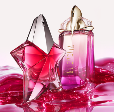 A purple Alien Hypersense perfume bottle surrounded by vibrant pink raspberries, delicate purple flowers, and soft feathers.