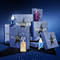 A collection of Mugler fragrance bottles and packages displayed against a dark blue background with sparkling accents. The scene highlights the distinctive star-shaped bottles alongside elegantly designed boxes.
