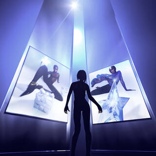 A silhouetted figure stands in front of two glowing screens, displaying artistic images of models posing with geometric shapes. The scene is illuminated by a bright light source above, creating a dramatic atmosphere.