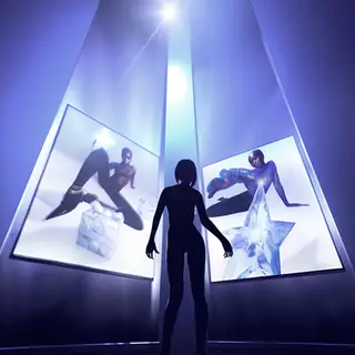 A silhouetted figure stands in front of two glowing screens, displaying artistic images of models posing with geometric shapes. The scene is illuminated by a bright light source above, creating a dramatic atmosphere.