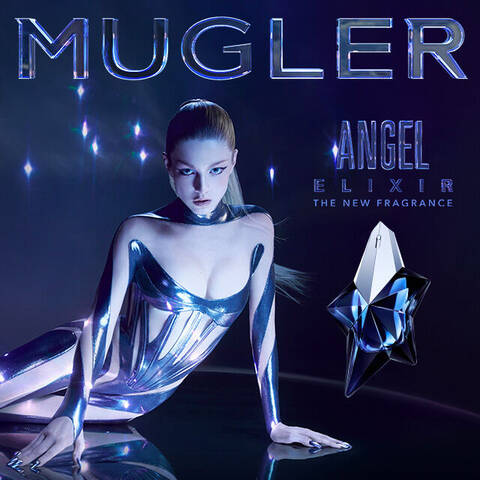 A model in a futuristic, reflective outfit poses against a dark background, promoting Mugler's new fragrance, Angel Elixir. The image features shimmering stars and the brand name prominently displayed.
