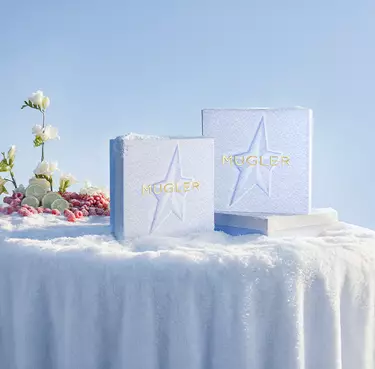 three snow themed Mugler gift boxes in a light icy setting