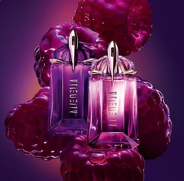Two purple and pink Alien Hypersense perfume bottles by Mugler, surrounded by large, glossy purple raspberries against a dark background.