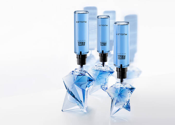 Three star-shaped glass bottles of Mugler Angel Eau de Parfum being refilled