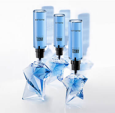 Three star-shaped glass bottles of Mugler Angel Eau de Parfum being refilled
