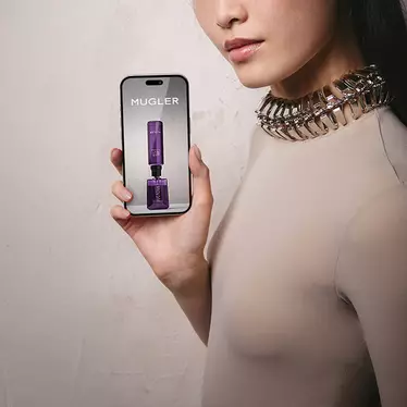 Close-up of model holding a smartphone with a blank screen.