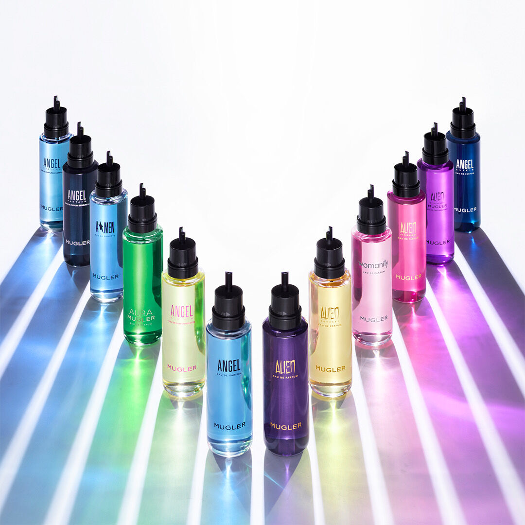A row of colorful Mugler refill bottles displayed on a white surface.