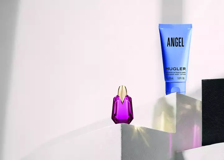 Mugler Angel perfume set with a miniature fragrance, body lotion, and a black notebook on display.