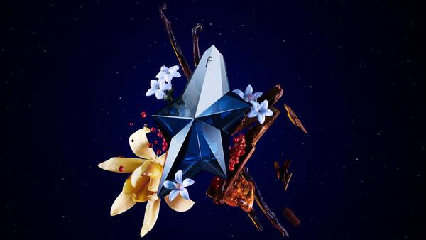 Visual of the "Angel Elixir" perfume featuring a striking blue and silver bottle surrounded by flowers, spices, and artistic elements on a dark starry background. Text reads "ANGEL ELIXIR" and "THE NEW FRAGRANCE."