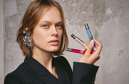 model holding three mini 10ml fragrances
