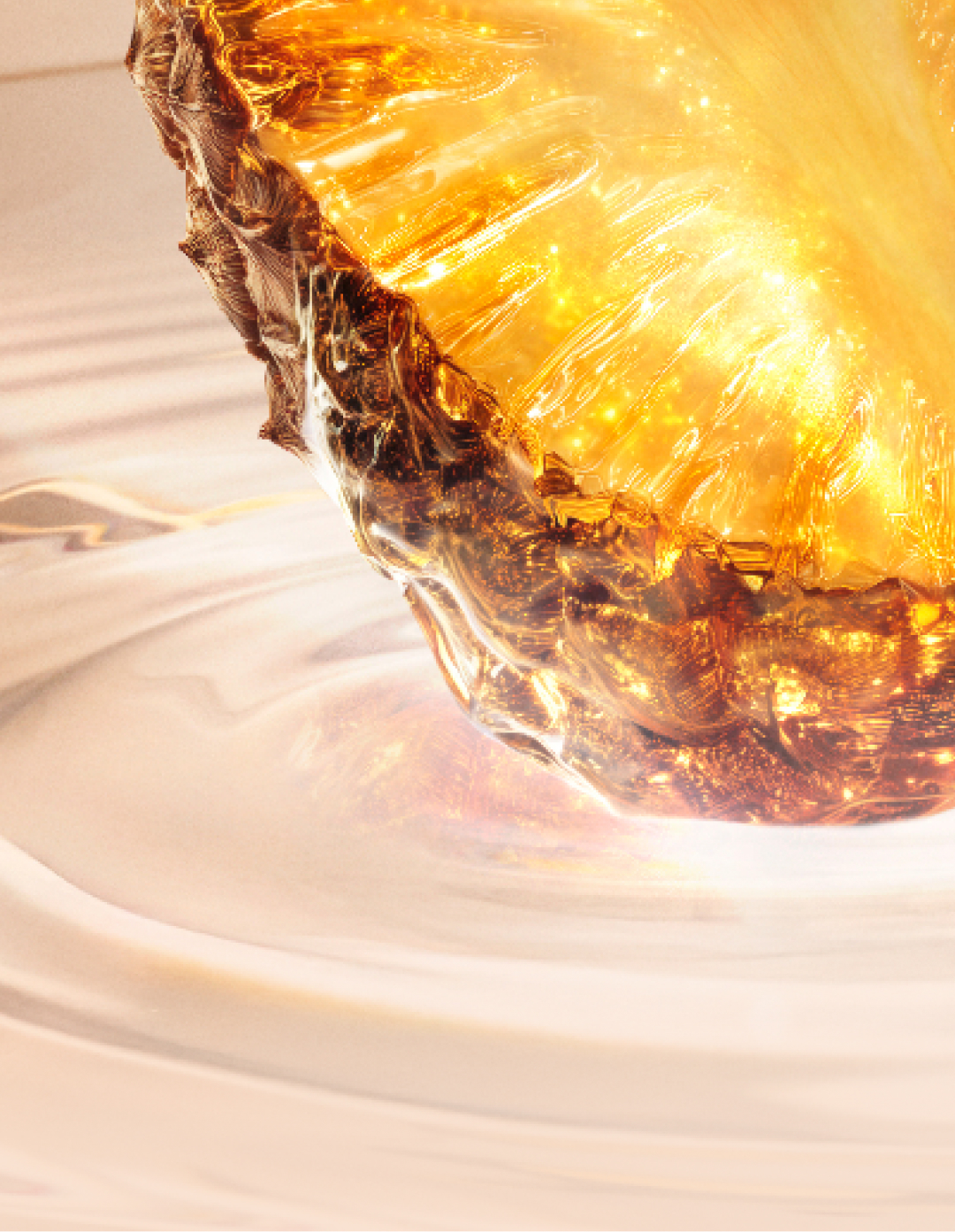 Gros plan sur une tranche d'ananas dorée, éclatante et lumineuse, partiellement immergée dans un liquide onctueux. Le texte la décrit comme une note vive et fraîche qui ouvre le parfum avec une énergie ensoleillée et irrésistible.