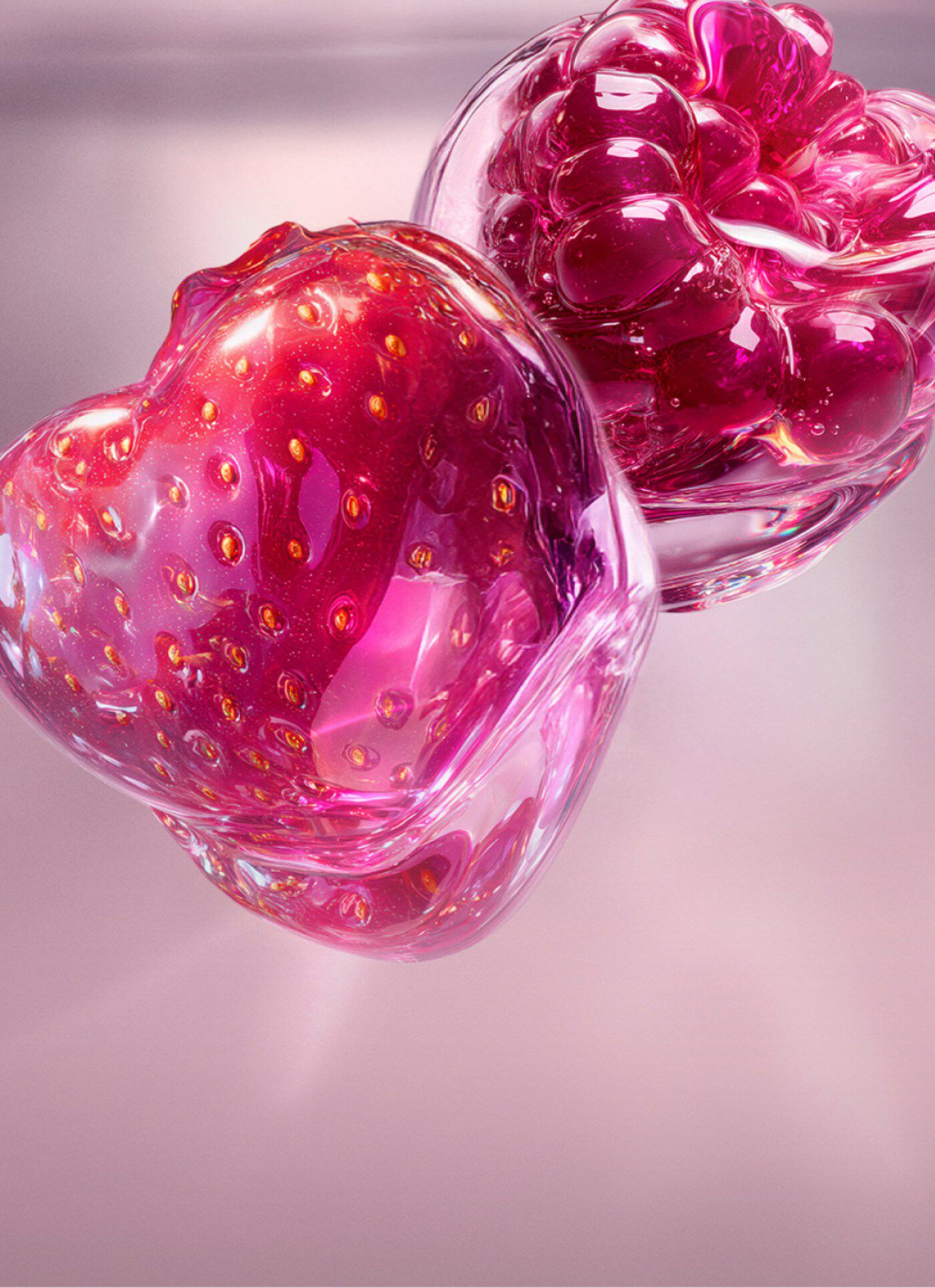A close-up of a strawberry and a raspberry, both encased in glossy, jewel-like translucent shells in shades of vibrant pink and deep red. The text describes it as a tender strawberry and sparkling raspberry combination that brings juicy, vibrant sweetness.