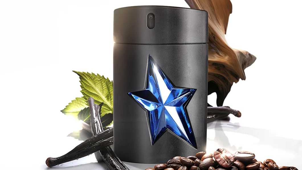A*Men Eau de Toilette black bottle with blue star logo beside blue refill bottle and vanilla ingredient accents.