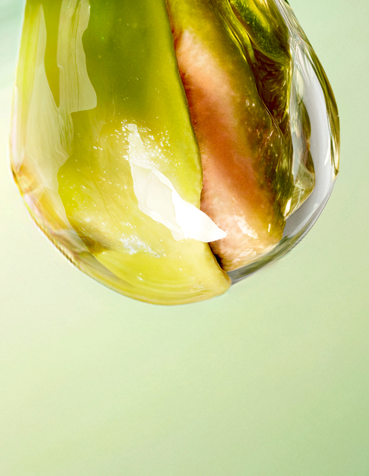 Gros plan sur une tranche d'ananas dorée, éclatante et lumineuse, partiellement immergée dans un liquide onctueux. Le texte la décrit comme une note vive et fraîche qui ouvre le parfum avec une énergie ensoleillée et irrésistible.