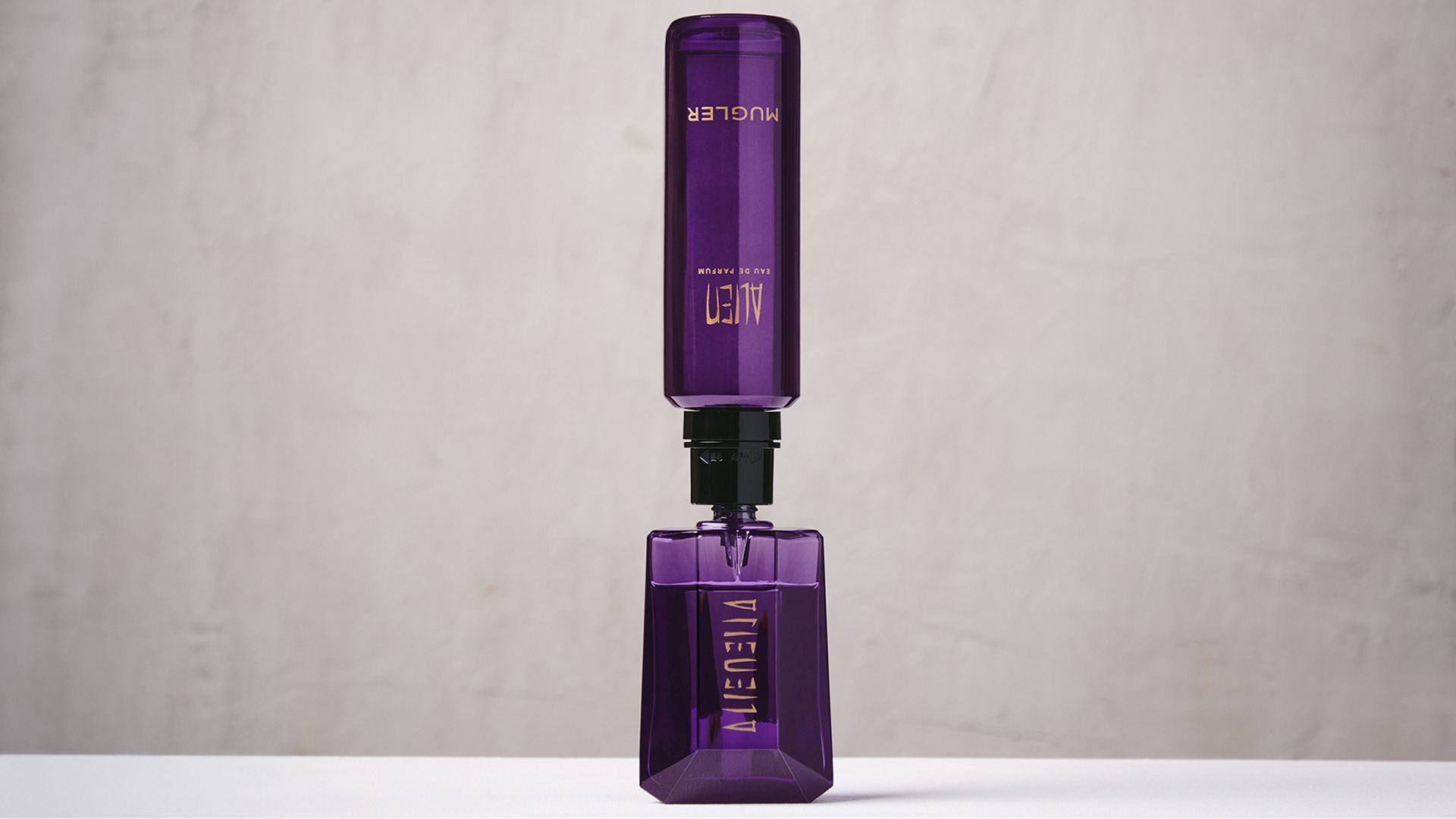 Purple Mugler Alien refill bottle connected upside down to matching perfume bottle