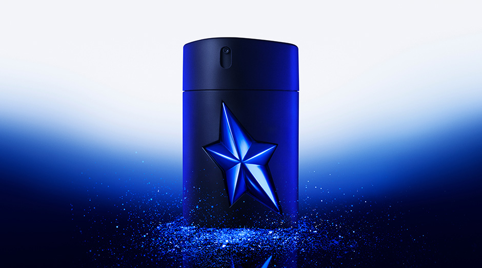an A*Men Stellar Eau de Parfum bottle is surrounded by dark blue glitter, on a dark blue gradient background