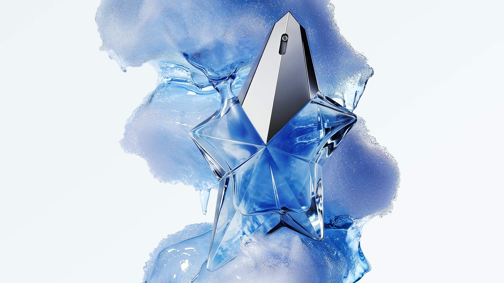 Angel Eau de Parfum bottle standing up, against a backdrop of one of Angel Eau de Parfum's key ingredients, caramelised cotton candy