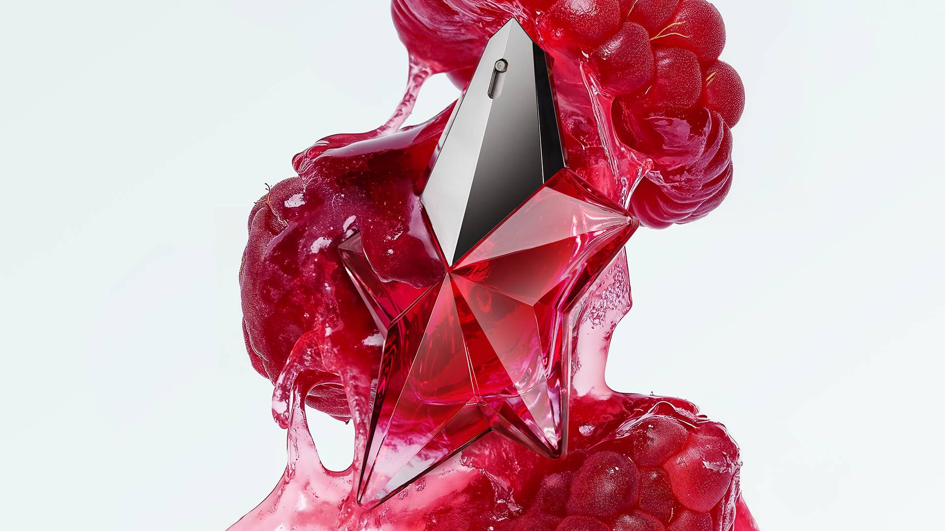Captivating red star-shaped perfume bottle surrounded by luscious red fruit pulp, suggesting a daring fruity floral woody fragrance.