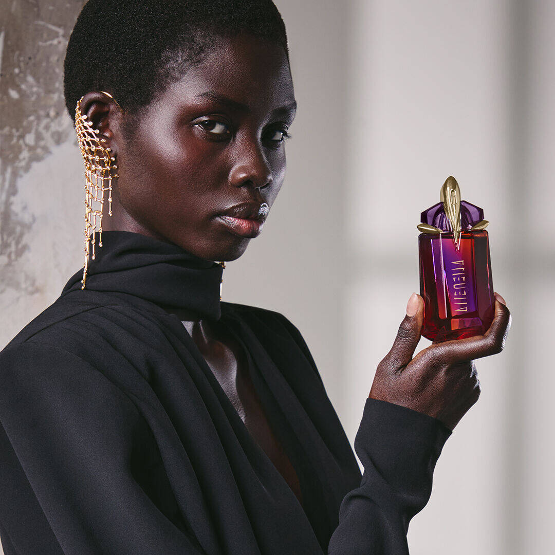 Model holding a bottle of Mugler Alien Hypersense Eau de Parfum.